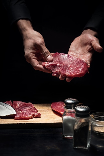 Gutes Rezept. Schließen Sie oben von den Köchenhänden, die Fleisch beim Kochen und Arbeiten im Restaurant halten.