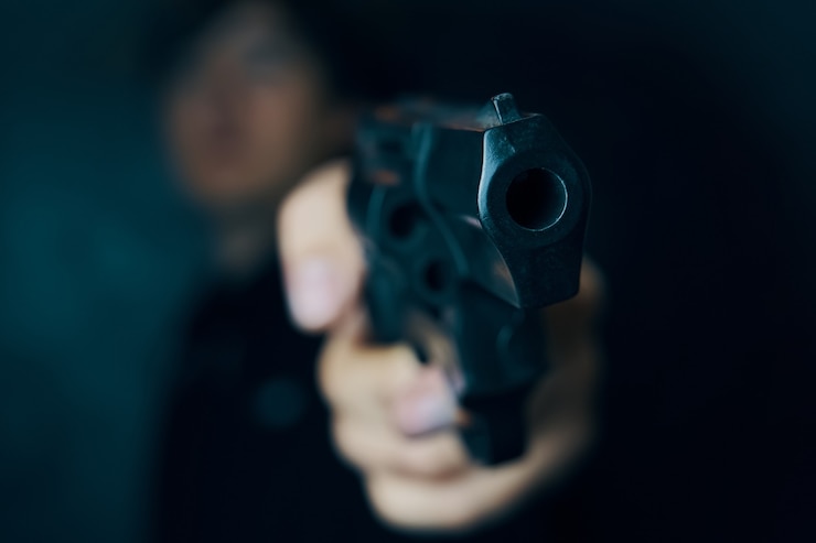 Foto guy ameaça com revólver de arma de fogo nas mãos do homem criminoso com um assassino armado ou ladrão armado