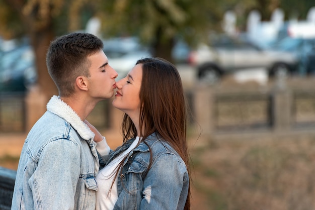 Guy beija suavemente a namorada no nariz. Retrato de casal apaixonado. Encontro romântico na cidade.