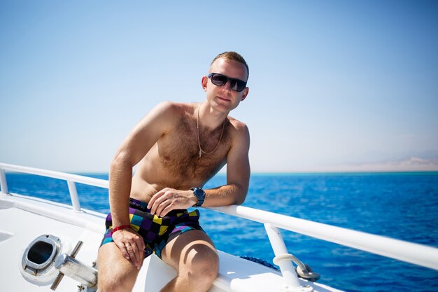 Guy Geschäftsmann in Shorts und Brille auf einer weißen Yacht im Roten Meer