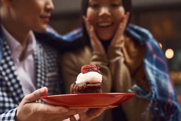 Guy Giving Cupcake para mujer joven encantada.