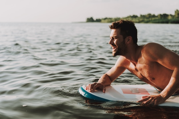 Guy Is Lays On Surf en el agua y nada.