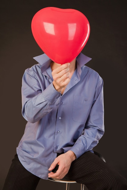 Guy sostiene un globo en forma de corazón