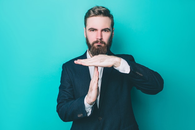 Guy en suite está de pie y muestra la señal de stop