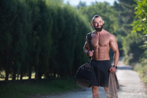 Guy vistiendo una bolsa de deportes al aire libre en el parque