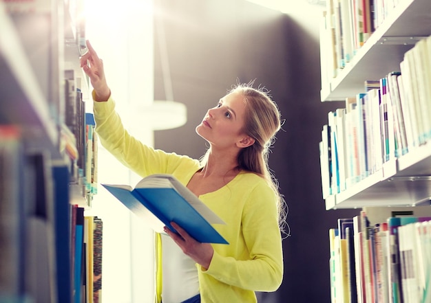 Gymnasiastin liest ein Buch in der Bibliothek