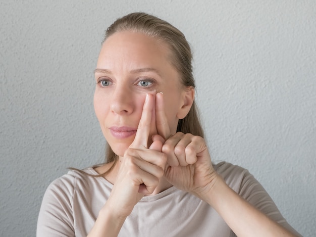 Gymnastik für das gesicht. frau macht verjüngende übungen für das gesicht