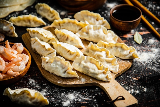 Gyoza de bolinhos crus com camarão numa tábua de cortar