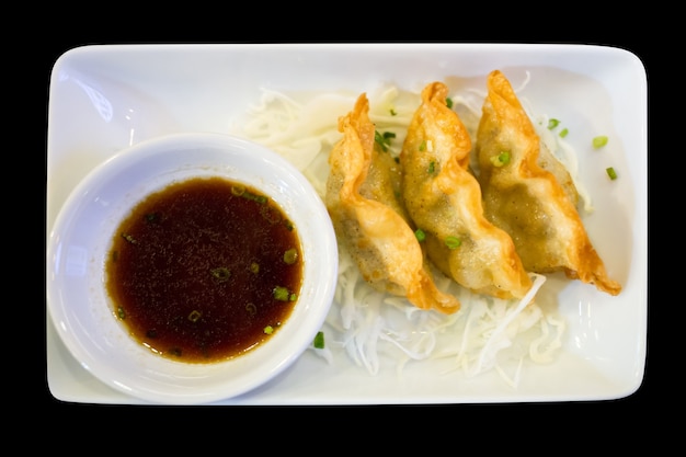 Gyoza o bolas de masa en un plato blanco, enfoque selectivo.