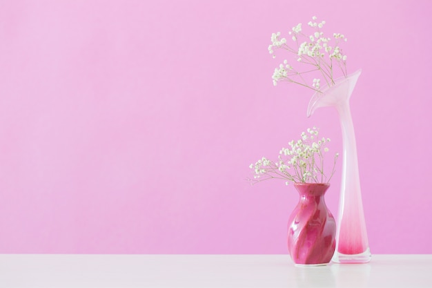 Gypsophila blüht in Vasen auf rosa Wand