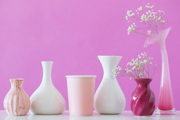 Gypsophila flores en jarrones sobre fondo rosa