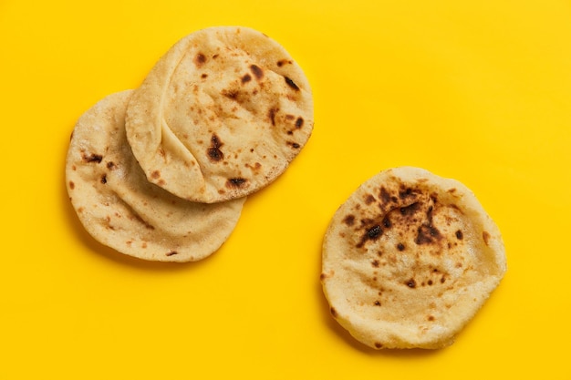 Ägyptisches Brot Aish Baladi auf viel frischem Brot liegt auf dem gelben Tisch