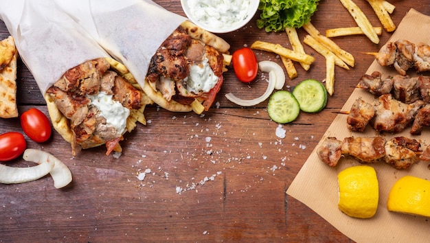 Gyro Pita Shawarma Souvlaki Zwei Fladenbrotpackungen und Fleischspieße auf Holztisch