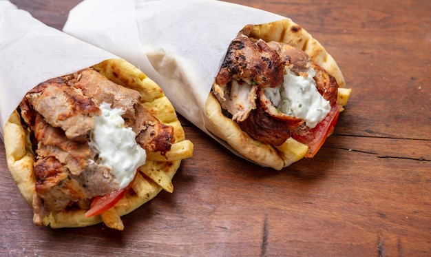 Gyro pita shawarma take away comida de rua Tradicional grego turco comida de carne na mesa de madeira