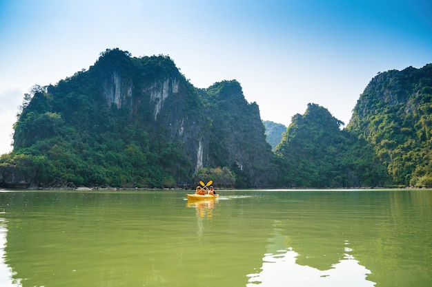 Ha Long VIETNAM 12. MÄRZ 2023 Touristendschunken, die zwischen Kalksteinfelsen in der Ha Long Bay schwimmen, Menschen, die in einer Höhle in der Lan Ha Bay in der Nähe der Halong Bay Vietnam Kajak fahren