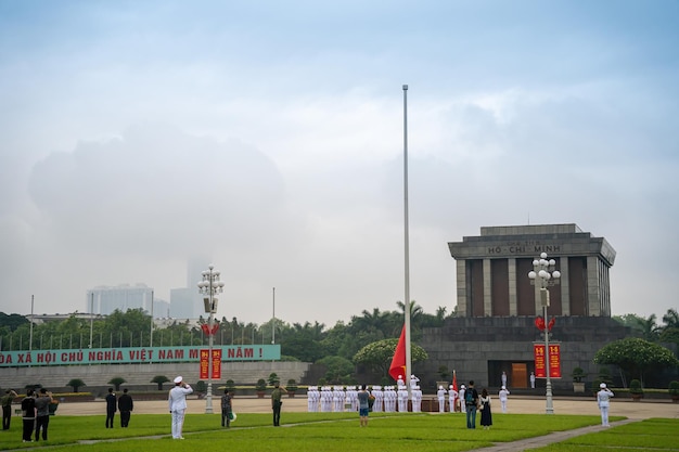 Ha Noi VIETNÃ 08 DE MAIO DE 2023 Mausoléu de Ho Chi Minh no centro da Praça Ba Dinh em Hanói, Vietnã Céu cinematográfico ao fundo Evento de hasteamento da bandeira Guarda em marcha