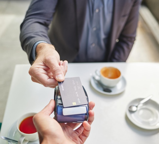 Ha pasado Foto de un hombre de negocios usando su tarjeta de débito para pagar el café