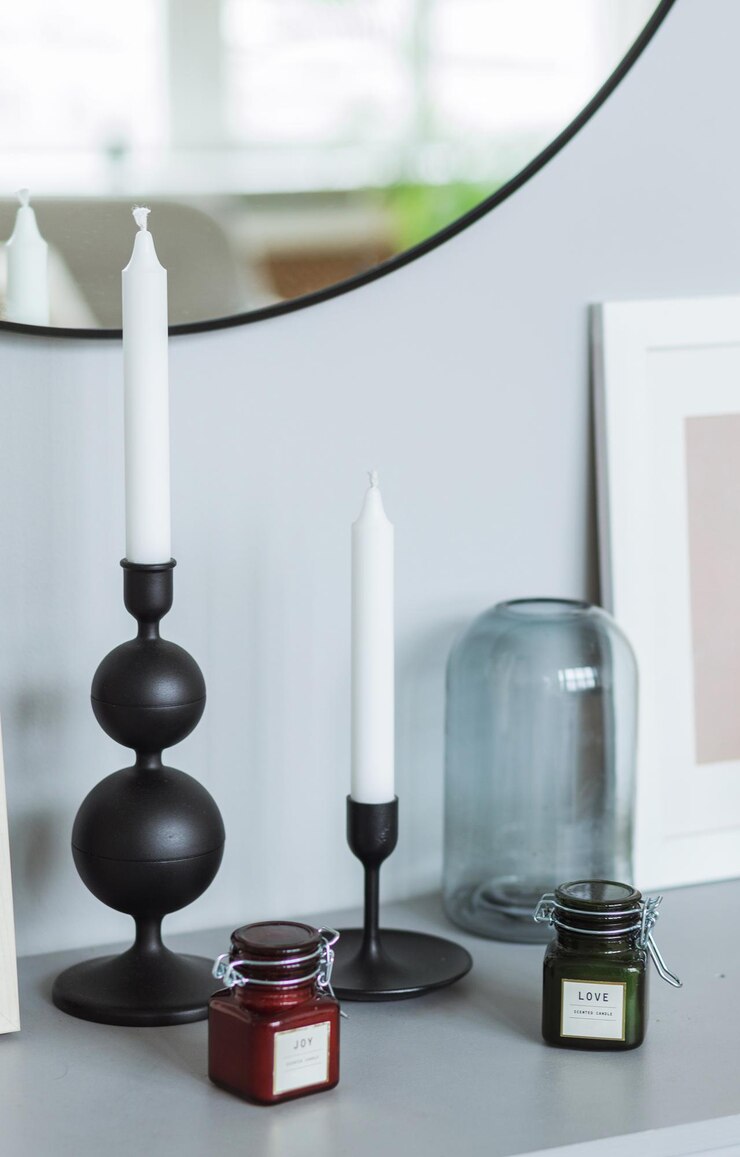Foto há uma cômoda perto da parede cinza com muitos detalhes internos. há um espelho na parede, velas, caixas e uma moldura na cômoda