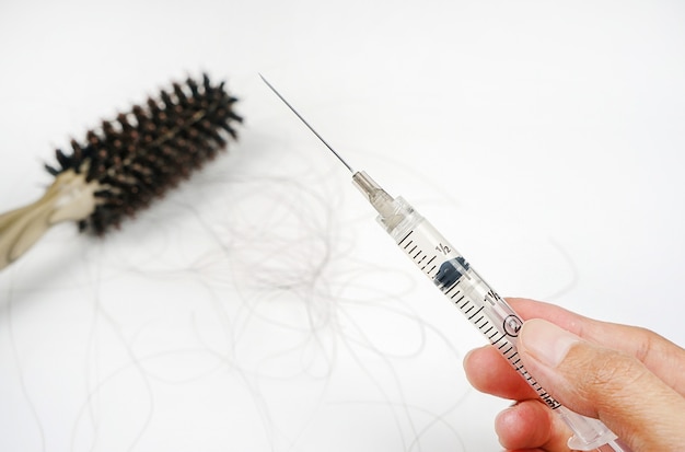 Haarausfall Haarausfall jeden Tag ernste Probleme konzentrieren sich auf das Haar mit einer Spritze in der Hand