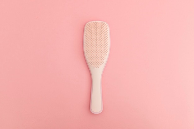 Haarbürste aus Kunststoff mit rosafarbenem Hintergrund