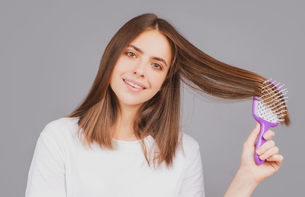 Haare bürsten Porträt junge Frau glattes natürliches Haar mit Kamm bürsten Mädchen kämmt gesundes Haar ...