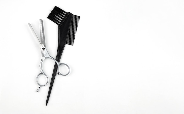 Haarfärbebürste mit Schere auf weißem Hintergrund Zubehör des professionellen Friseurs