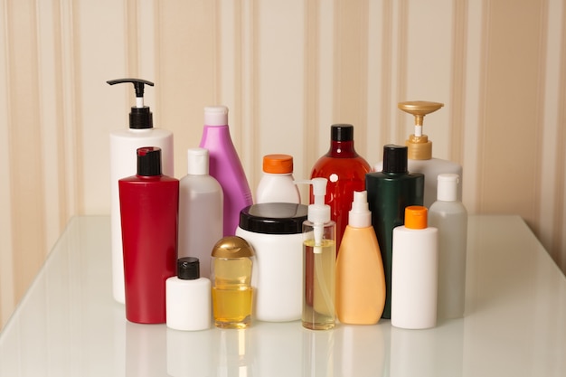Haarpflege- und Behandlungsprodukte: Shampoo, Conditioner, Maske, Öl und Serum auf beigem Hintergrund