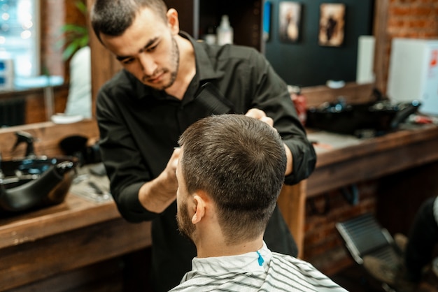 Haarschnitt beim Friseur. Barber schneidet dem Kunden die Haare auf den Kopf