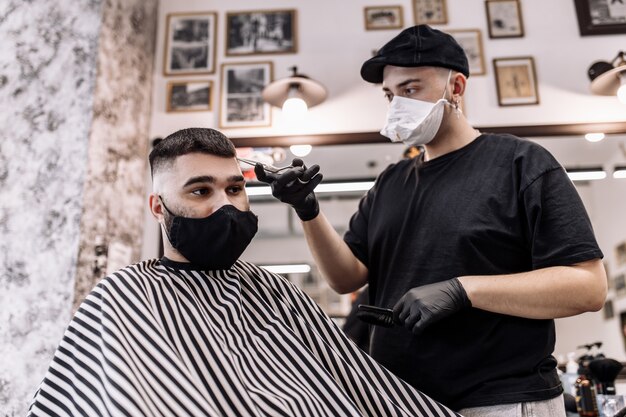 Haarschnitt in Quarantäne. Haarschnitt in Masken vom Virus. Haar- und Gesundheitsfürsorge. Mann Haarschnitt in