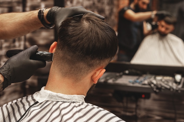 Haarschnittkopf im Friseursalon, Friseur schneidet das Haar auf dem Kopf des Kunden.