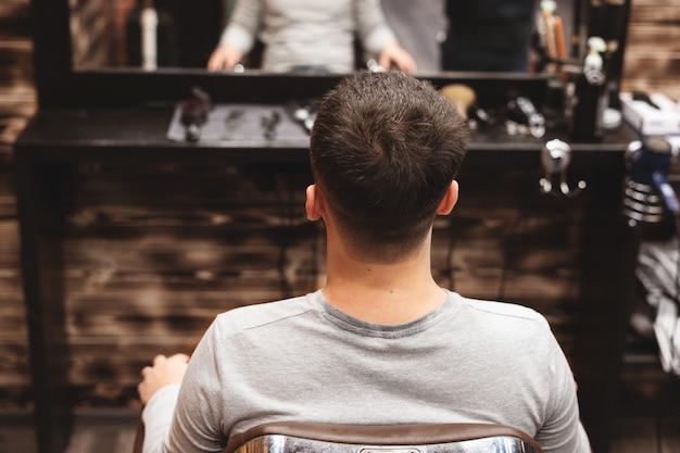 Haarschnittkopf im Friseursalon. Friseur schneidet Haar auf Kopf des Kunden. Der Prozess der Schaffung von Frisuren für Männer. Friseur.