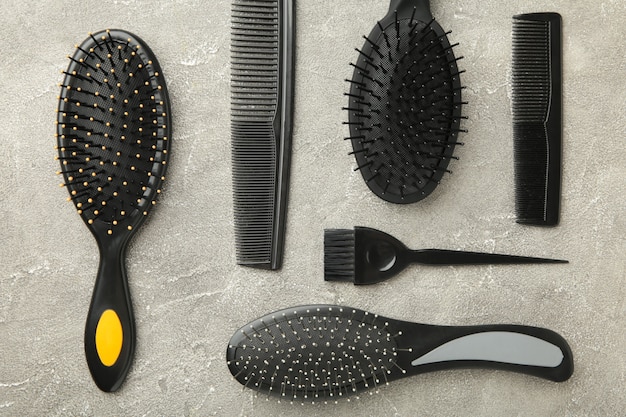 Haarwerkzeuge, Schönheits- und Friseurkonzept - verschiedene Bürsten oder Kämme auf grauer Oberfläche