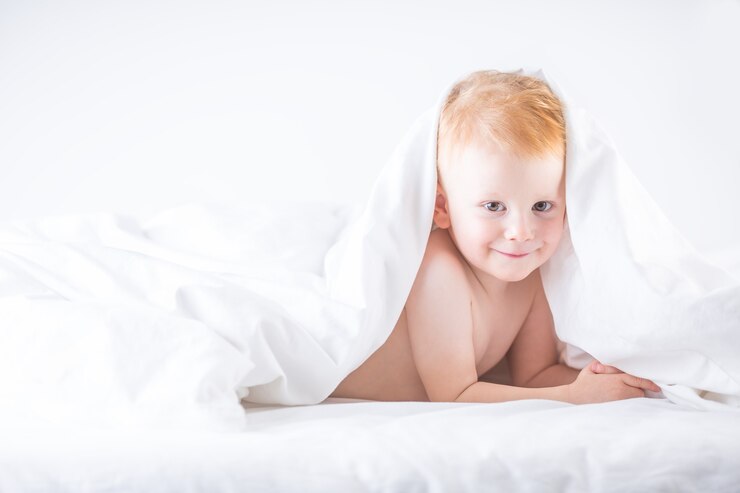 Habby joven niño smilling en cama blanca.