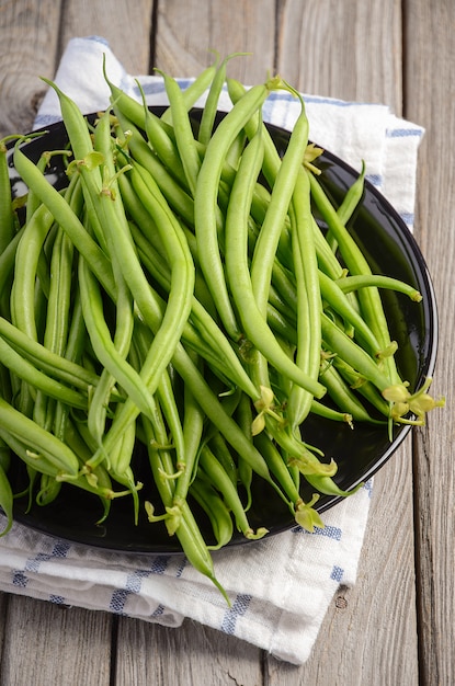 Habichuelas verdes en la mesa de madera rústica.