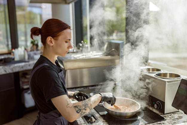 Un hábil chef está cocinando activamente en una cocina moderna llena de vapor y deliciosos aromas