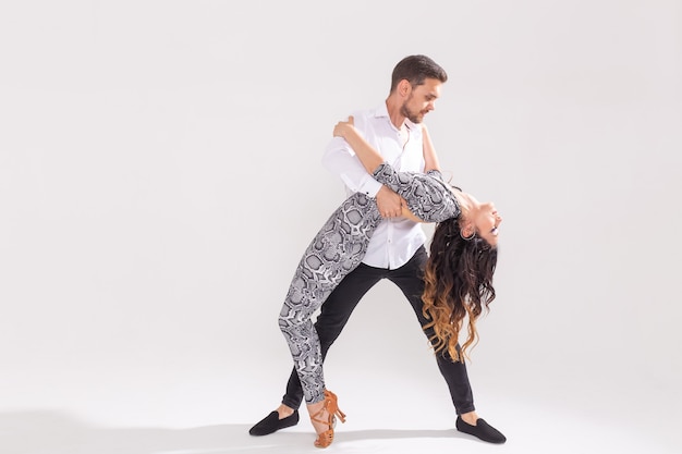 Hábiles bailarines actuando en el fondo blanco con espacio de copia. Pareja sensual realizando una danza contemporánea artística y emocional