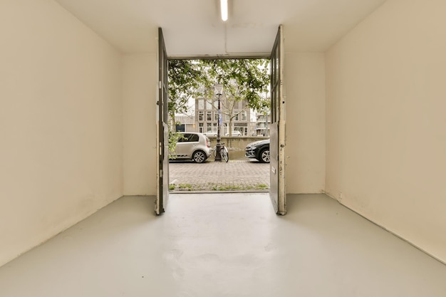 Una habitación blanca con una puerta abierta a una calle.