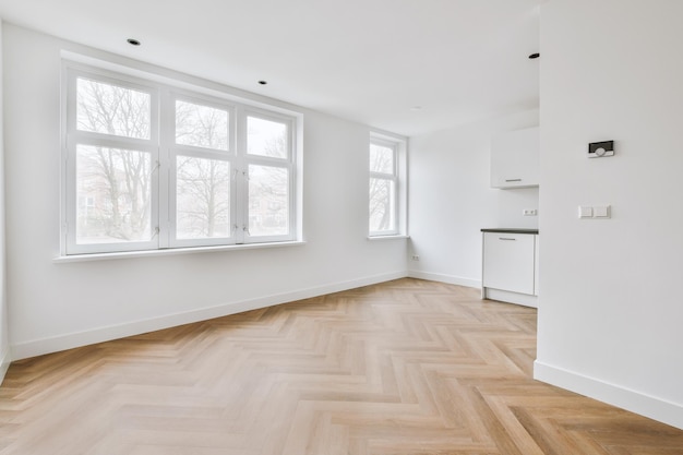 Habitación blanca vacía con parquet de madera y buen brillo.