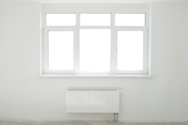 Foto habitación blanca con ventana llena de luz.