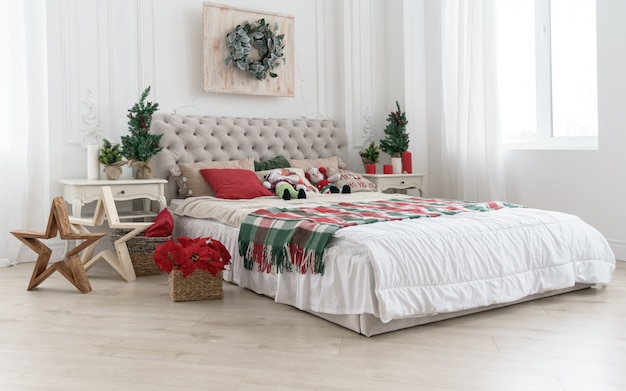 Habitación decorada para vacaciones de Navidad con árboles y flores en sala blanca