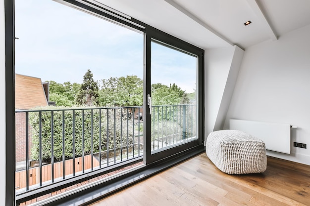 Habitación elegante con una gran ventana y una otomana.