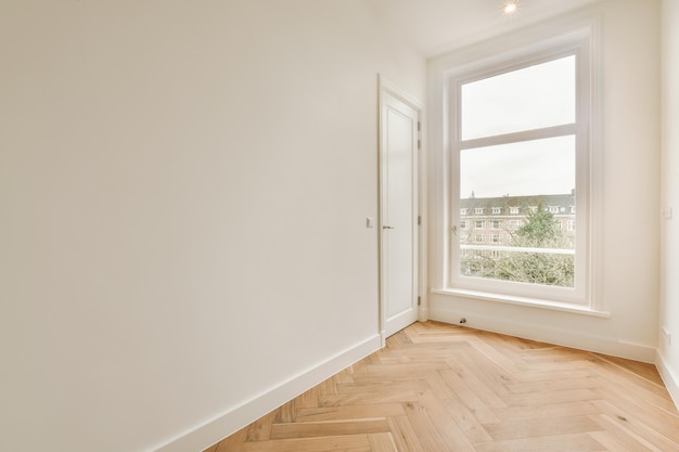 Una habitación espaciosa con suelos de parquet en colores vivos y grandes ventanales en una casa moderna