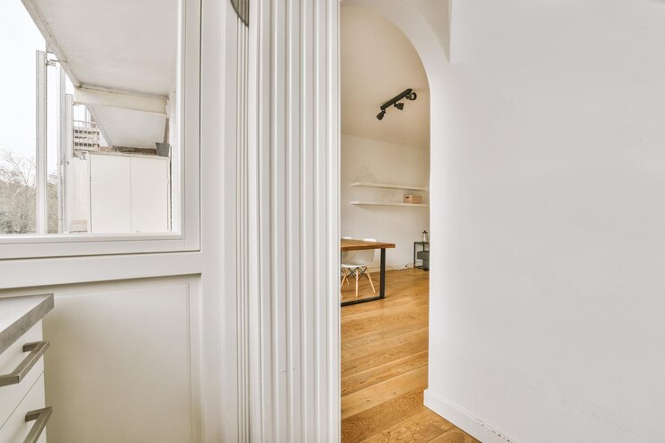 Una habitación con una gran puerta blanca y una ventana.
