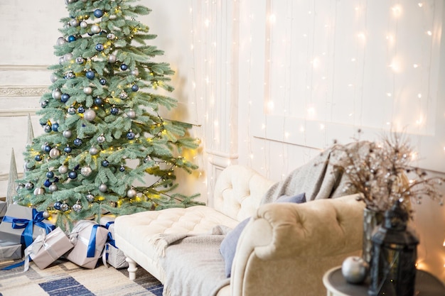 La habitación de invitados está decorada para Navidad un árbol con regalos y juguetes bolas de Navidad