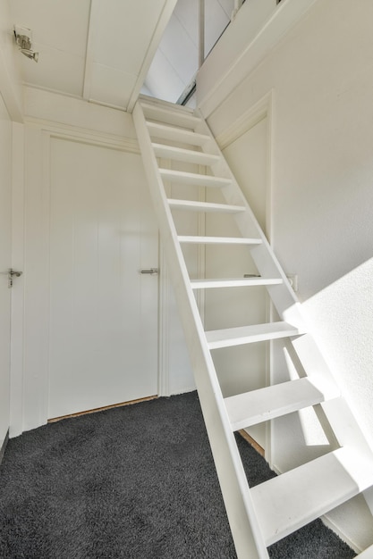 Una habitación minimalista simple con una escalera blanca al ático.