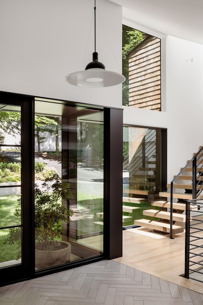una habitación con una puerta negra y blanca que tiene una lámpara negra y blanca en ella