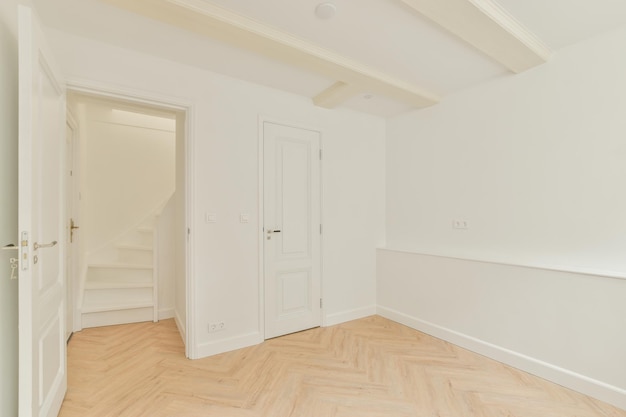 Habitación vacía con paredes blancas y suelo de parquet