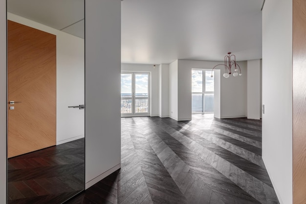 Habitación vacía con suelo laminado flotante de madera oscura Interior de la casa amplio dormitorio o sala de estar