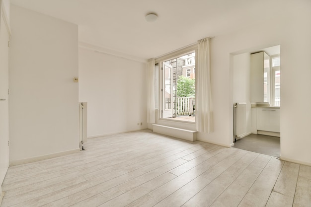 Habitación vacía con ventana panorámica y radiador.