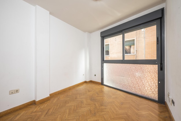 Habitación con ventanas de aluminio anodizado gris con vidrio con film semitransparente paredes blancas y pisos de madera de roble